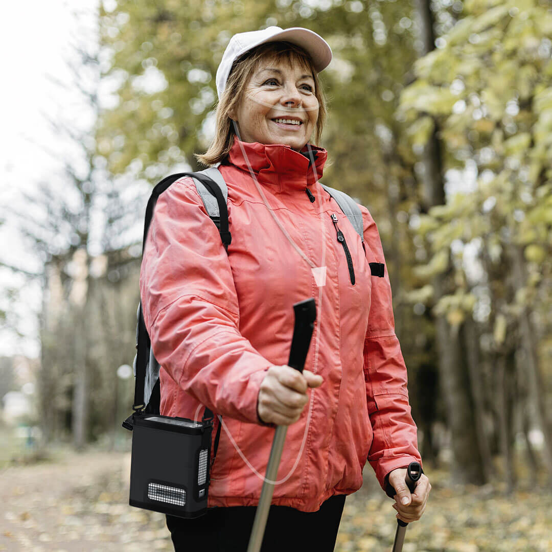 Mujer mayor caminando al aire libre con el concentrador de oxígeno portátil VP-8G
